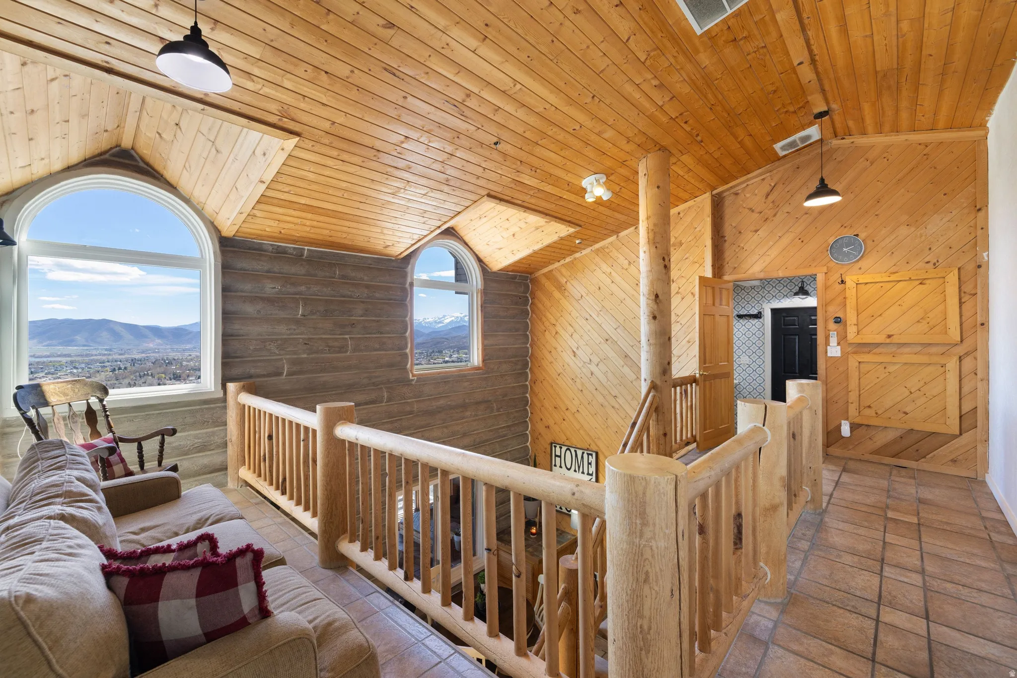 Corridor featuring a mountain view, a high wooden ceiling, an upstairs landing, and log walls