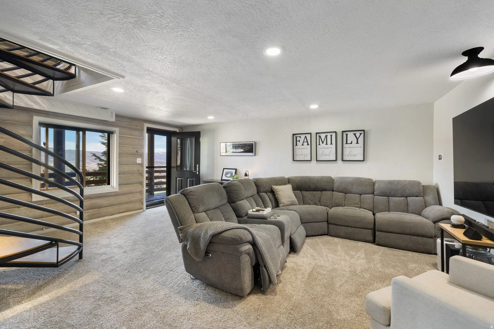 Living room with a textured ceiling, carpet floors, and recessed lighting