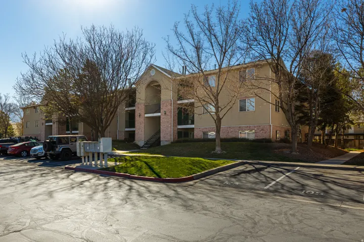 View of apartment building / complex featuring uncovered parking and stairway