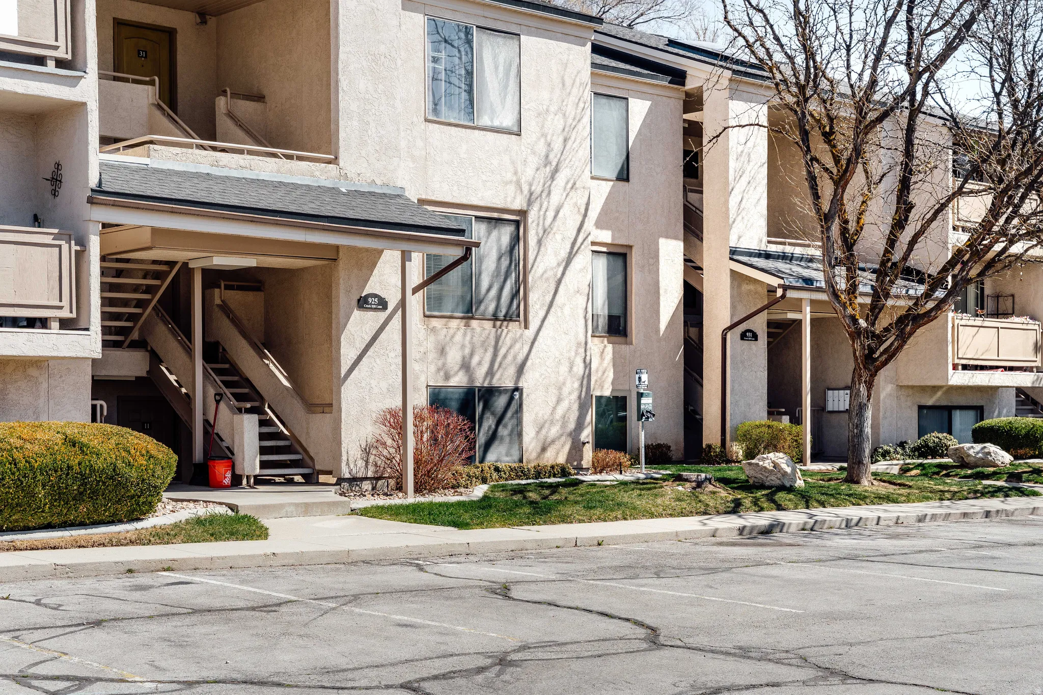 View of apartment building / complex with stairs and uncovered parking