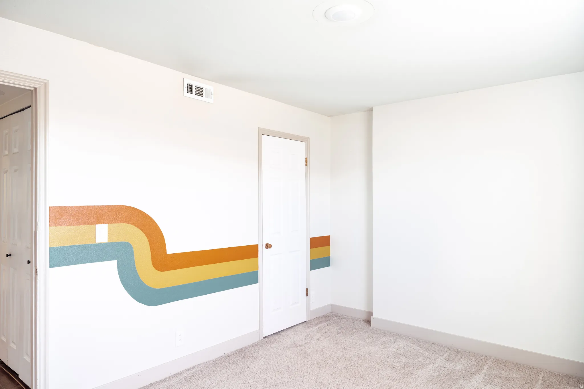 Spare room featuring light carpet and baseboards