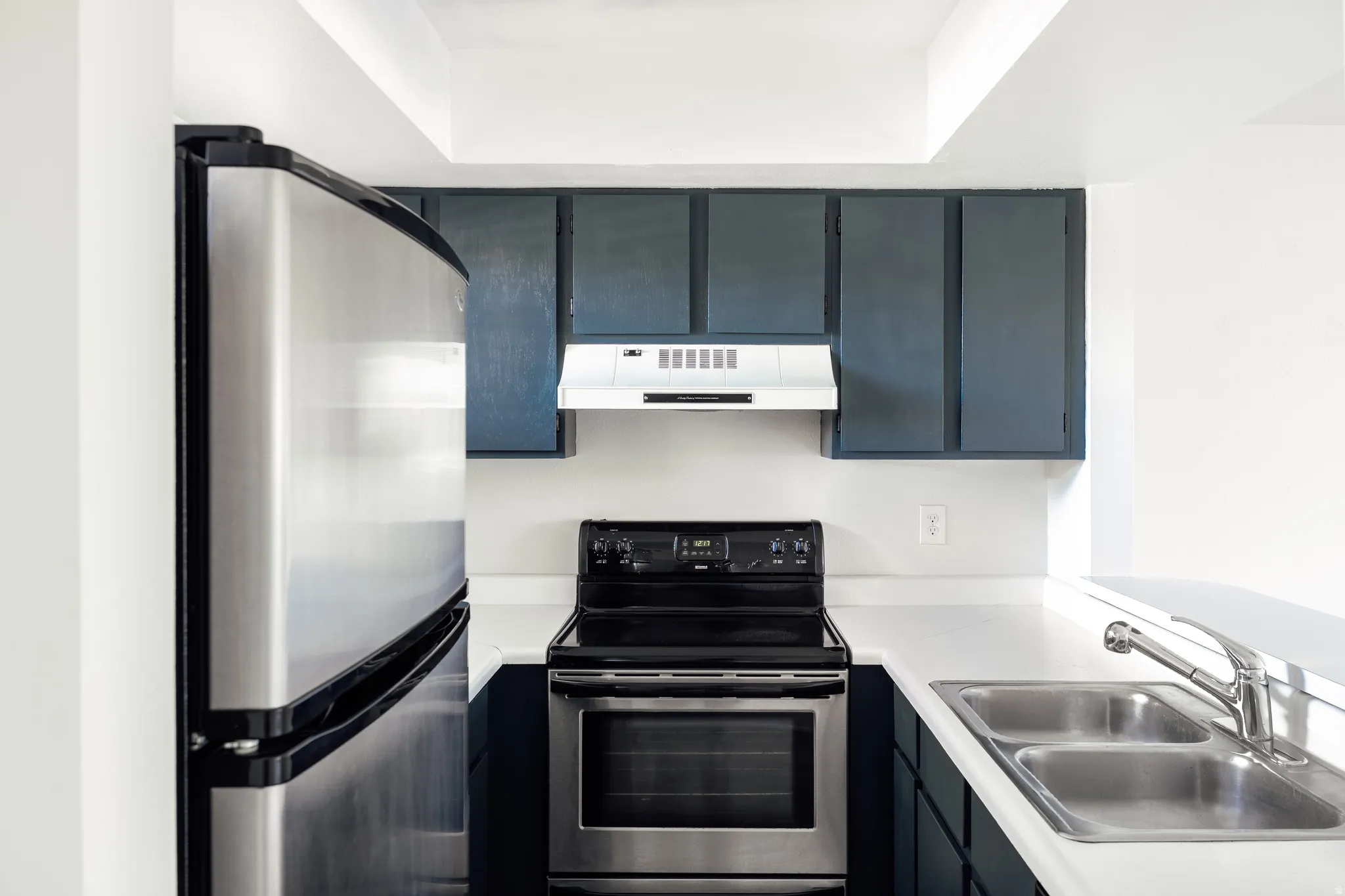 Kitchen with stainless steel appliances and light countertops
