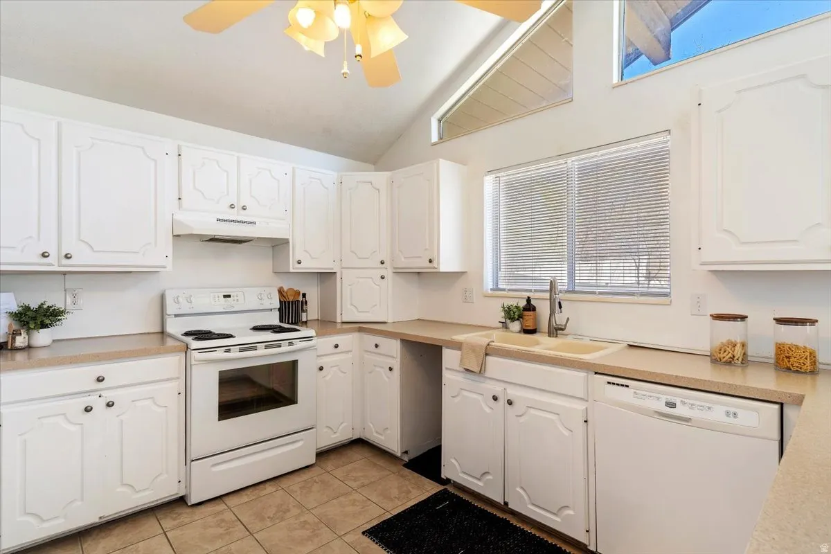 Kitchen featuring white appliances, ceiling fan, white cabinetry, light countertops, and light tile patterned floors