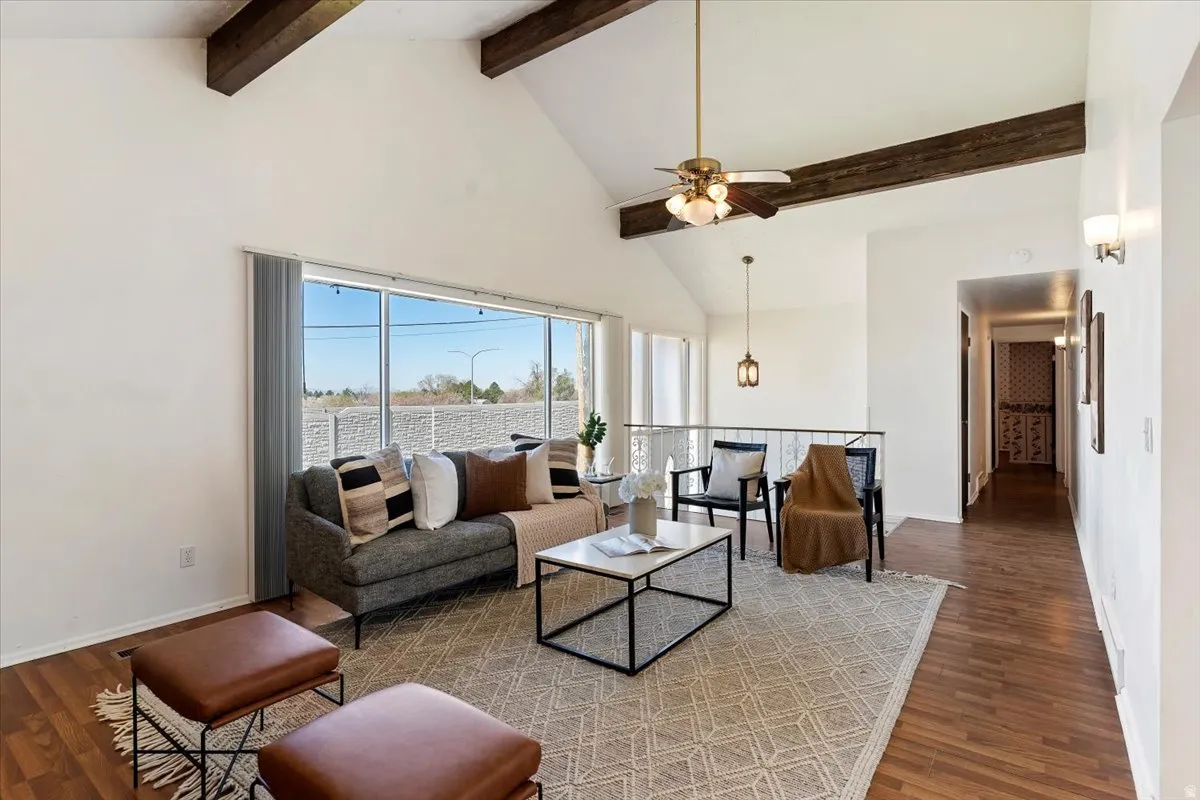 Living area featuring a ceiling fan and dark wood-style flooring