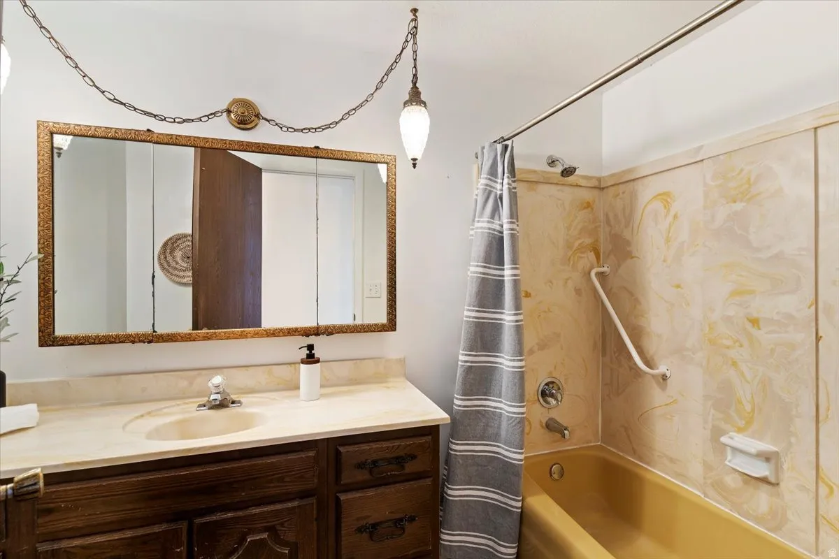 Bathroom featuring vanity and shower / bath combo with shower curtain