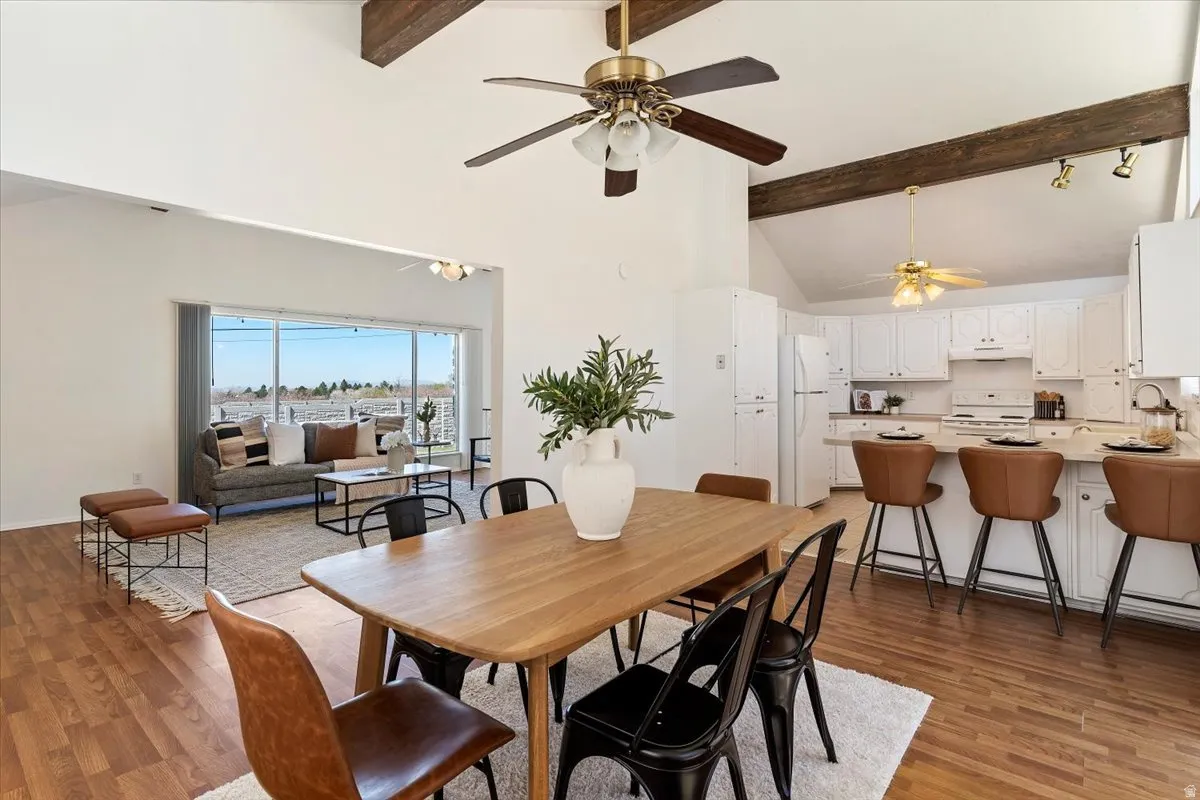 Dining space with light wood-style floors, vaulted ceiling, and ceiling fan