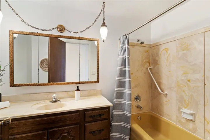 Bathroom featuring vanity and shower / bath combo with shower curtain