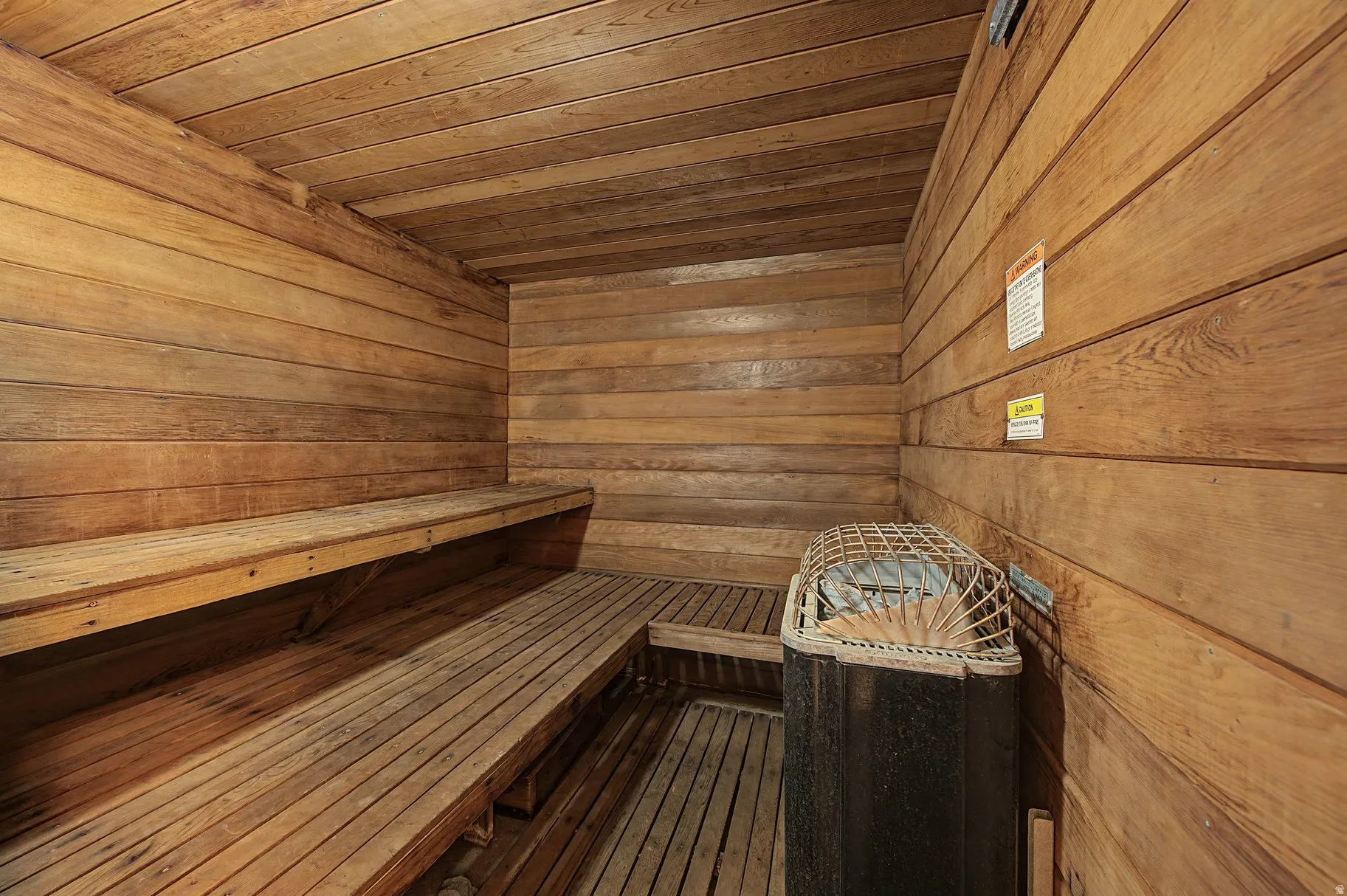 Relaxing sauna featuring wooden ceiling and wood walls