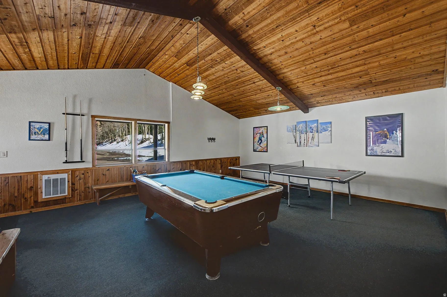 Recreation room with a high wood beamed ceiling, wooden walls, wainscoting, and billiards table