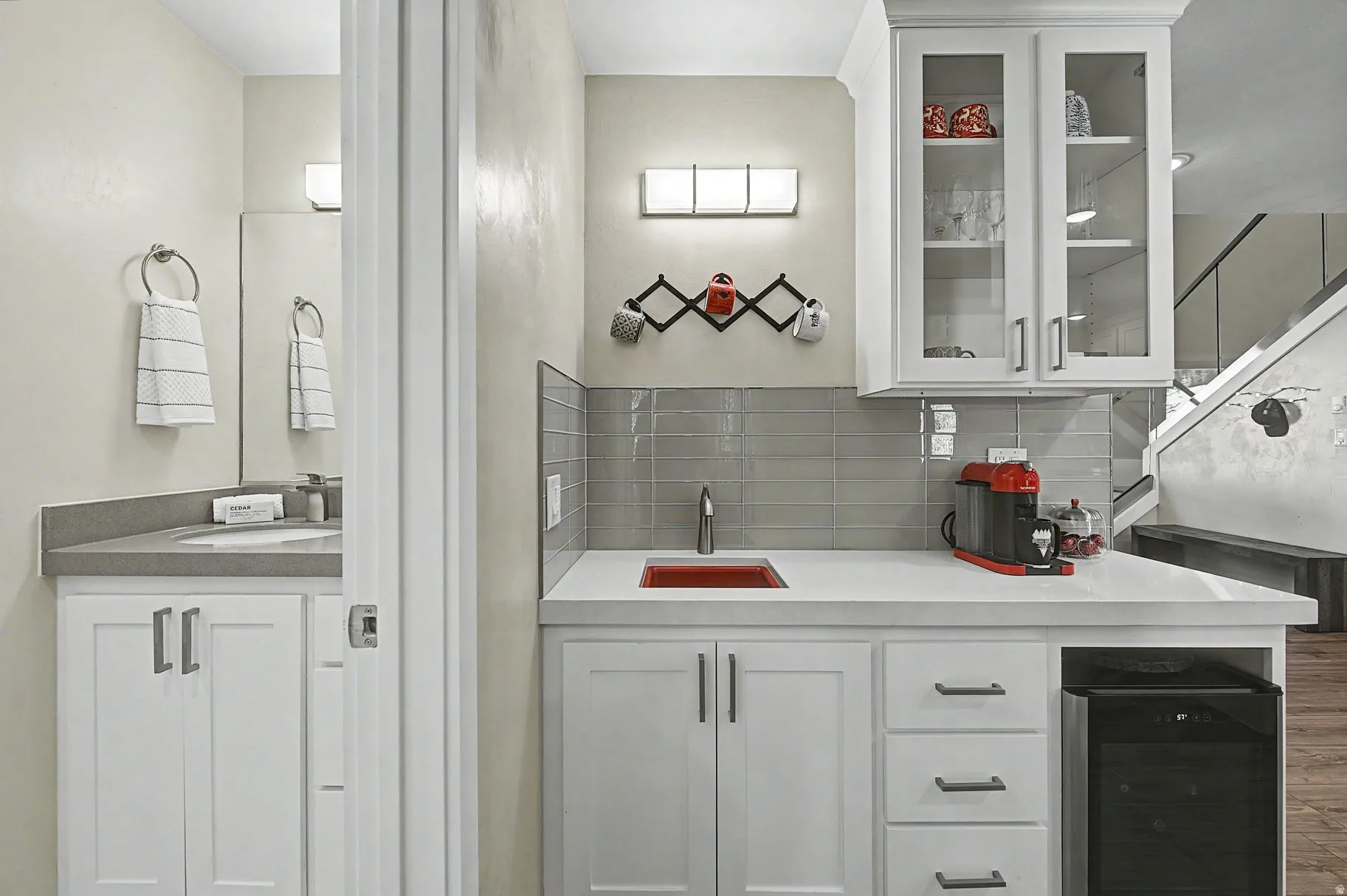 Kitchen featuring white cabinetry, glass insert cabinets, beverage cooler, backsplash, and light stone counters