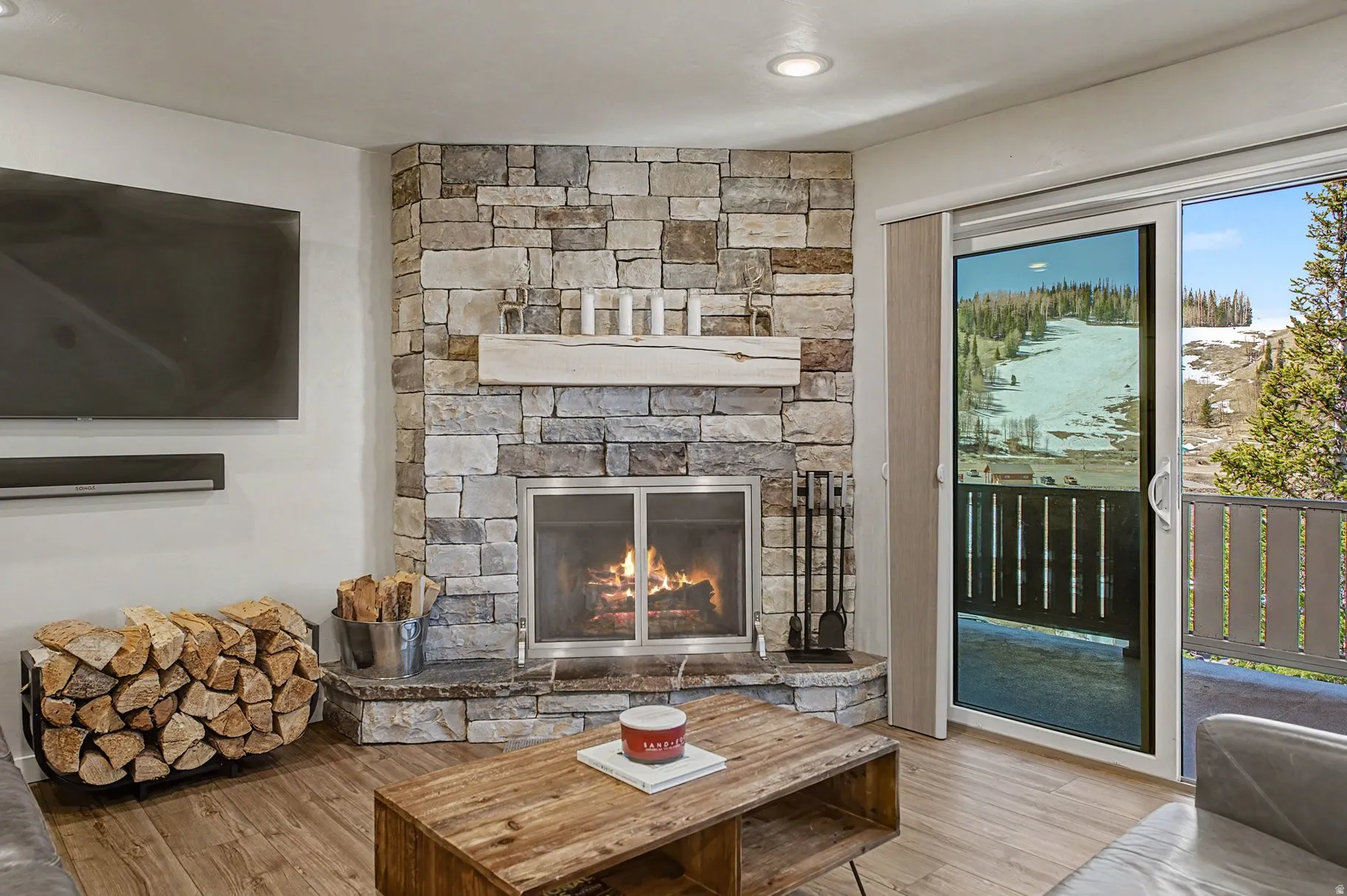 Detailed view of wood finished floors and a stone fireplace