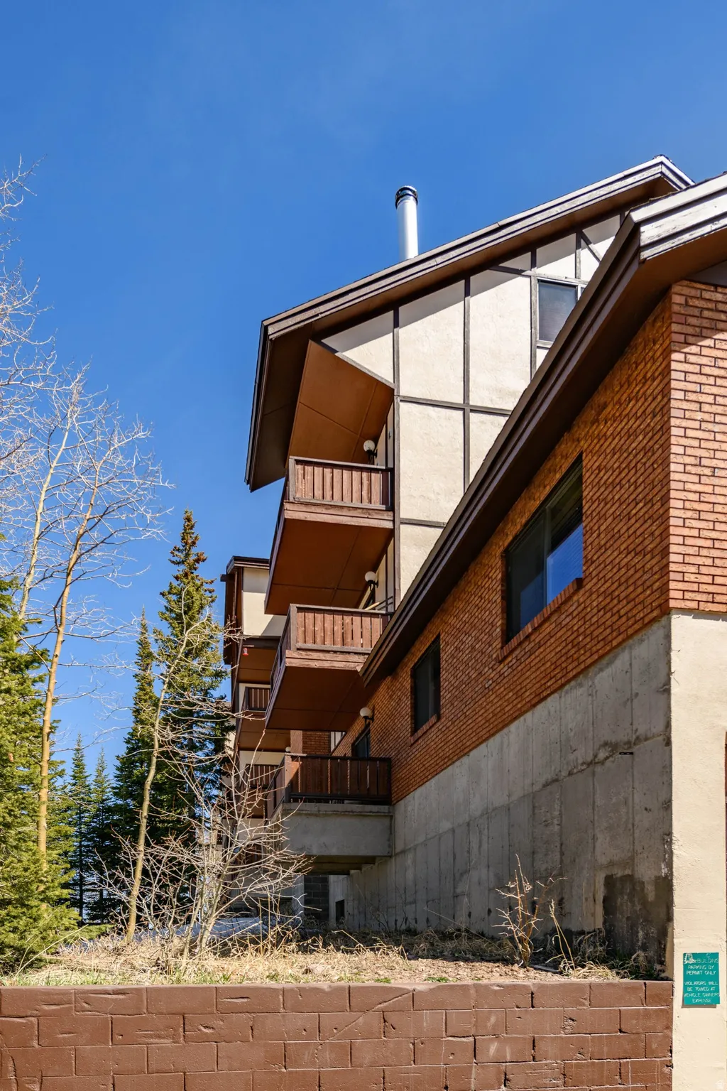 View of property exterior with a balcony and brick siding