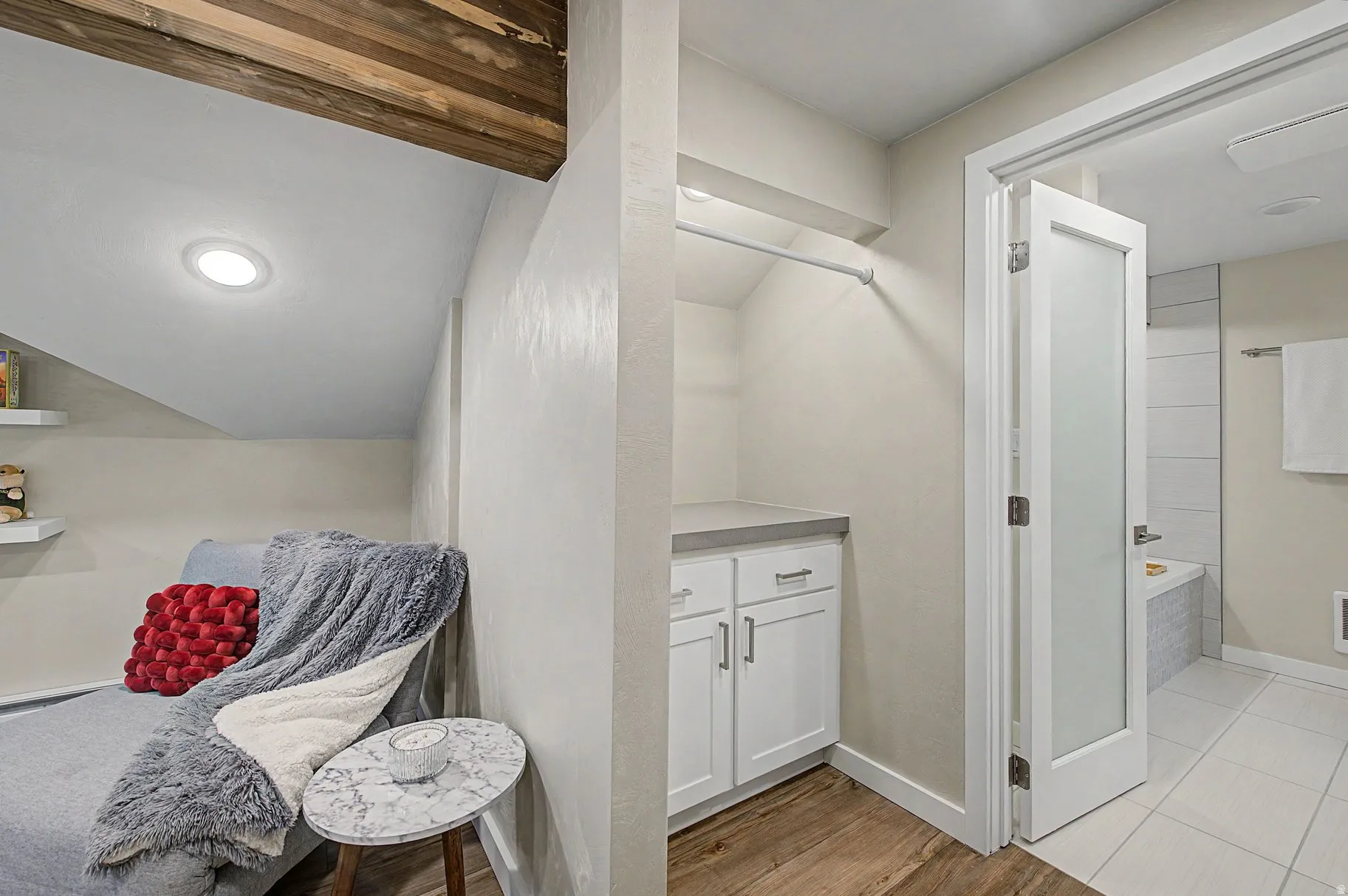 Full bath with tiled tub, vanity, and light wood-type flooring