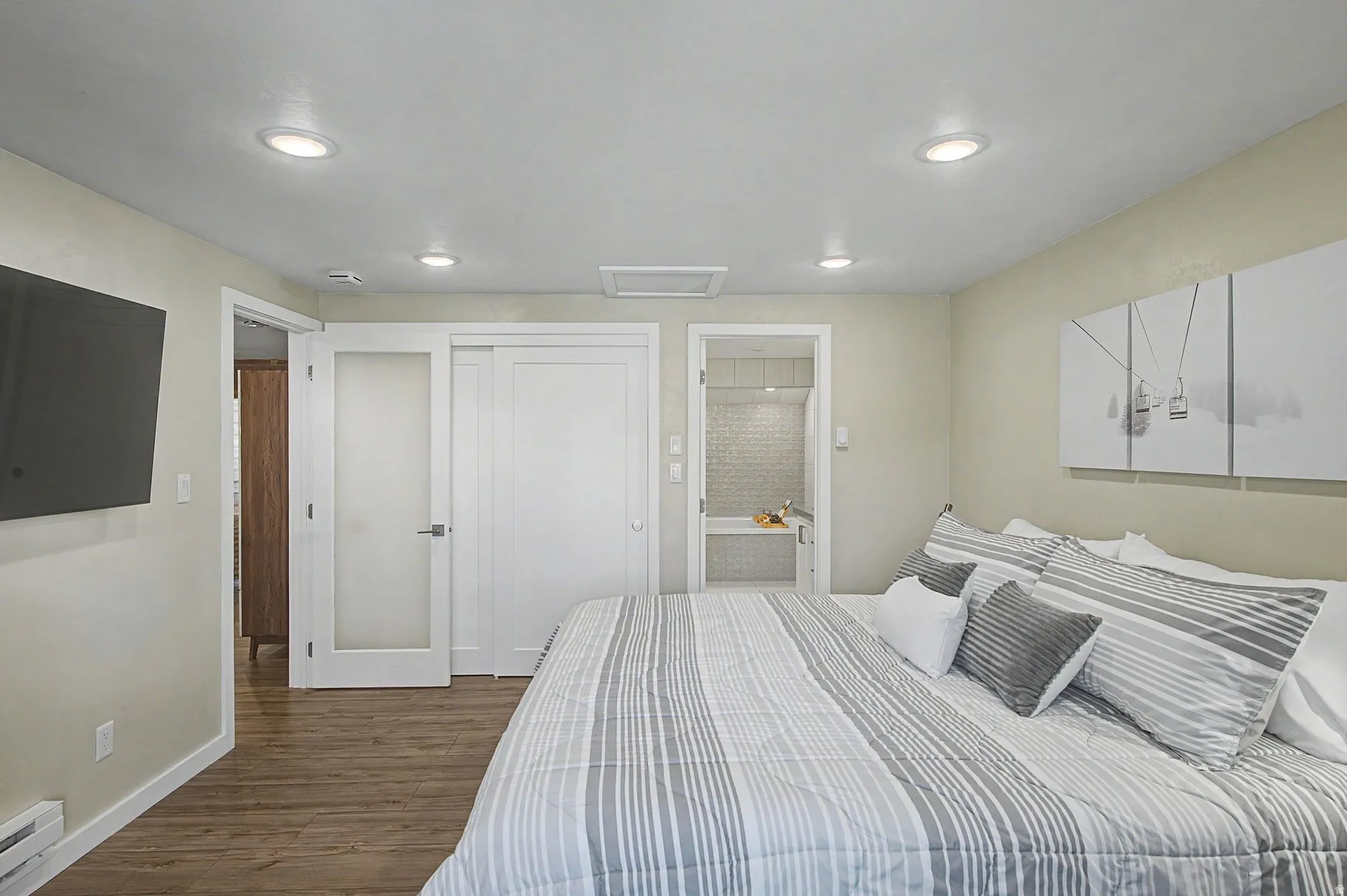 Bedroom featuring dark wood-style flooring, connected bathroom, a baseboard radiator, a closet, and recessed lighting