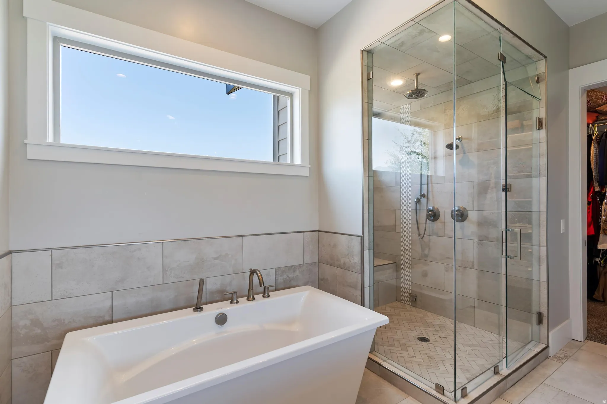 Bathroom featuring a walk in closet, a freestanding bath, a stall STEAM shower, and recessed lighting