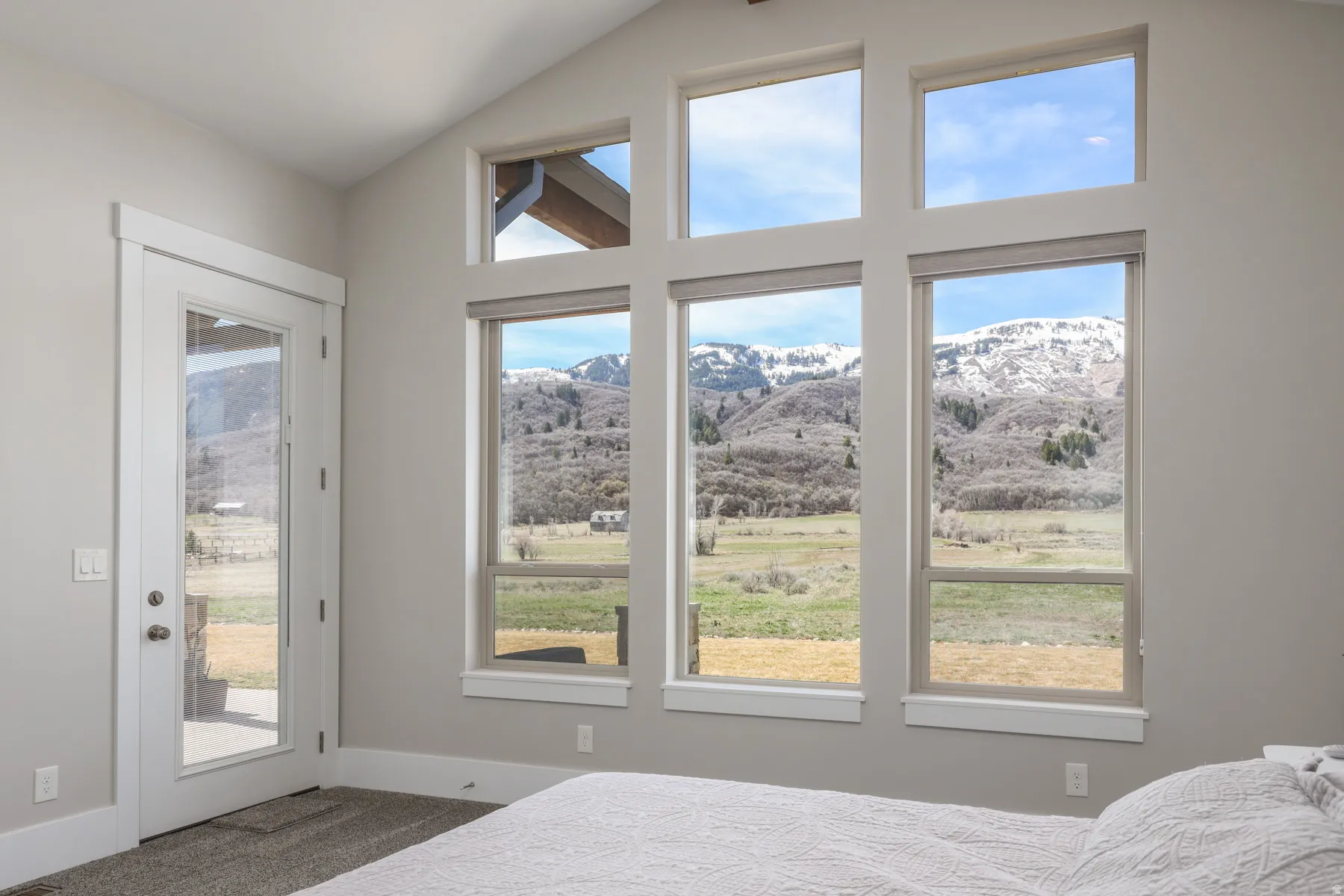 Bedroom with a mountain view, access to exterior, dark carpet, and lofted ceiling