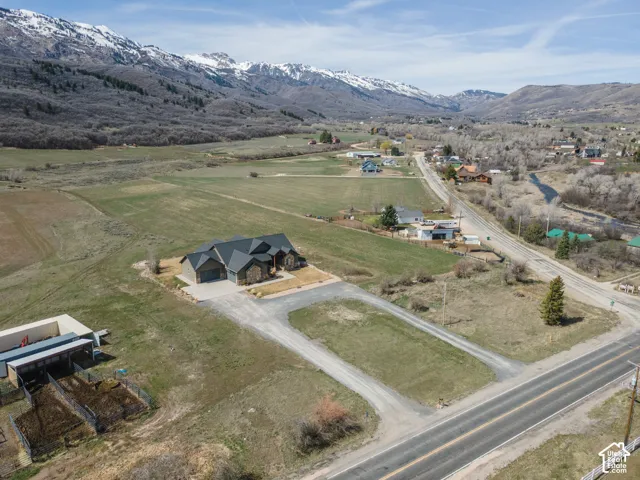 Aerial view of property and surrounding area featuring rural landscape and a mountainous background