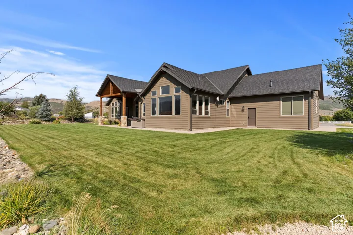 Rear view of property with a yard, a patio, roof with Presidential shingles, and a Mountain View’s