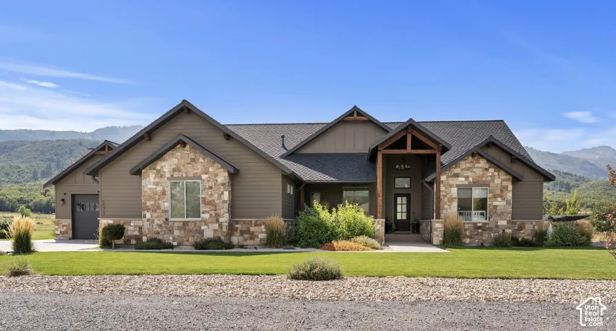 Craftsman inspired home with a mountain view, stone siding, custom timber beams.