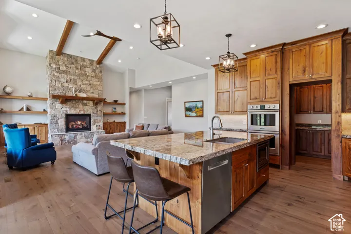Kitchen with gas range, custom walnut wood cabinets, granite and large island. Opening to living room.