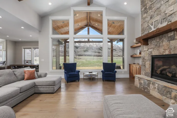 Living area with a stone fireplace, hardwood / wood-style flooring, recessed lighting, and a mountain view