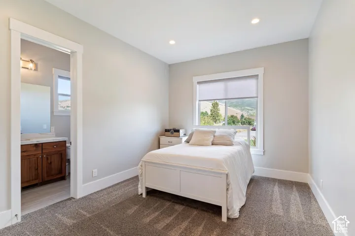 Bedroom with ensuite bath, and recessed lighting