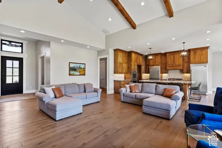Living area featuring light wood flooring, recessed lighting, and vaulted ceiling.