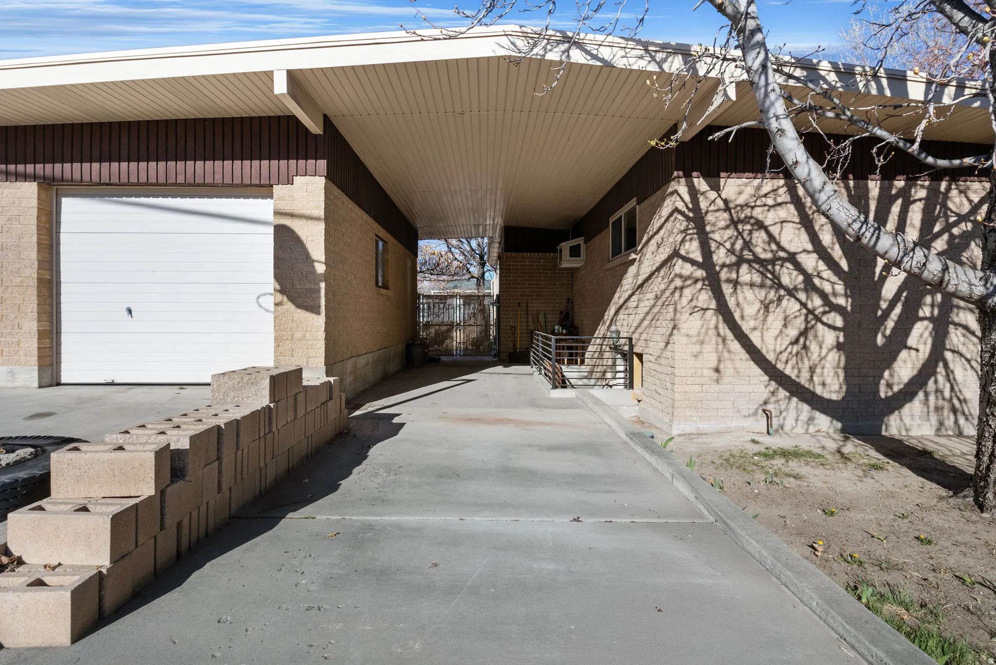 View of side of home with attached carport and basement entrance.