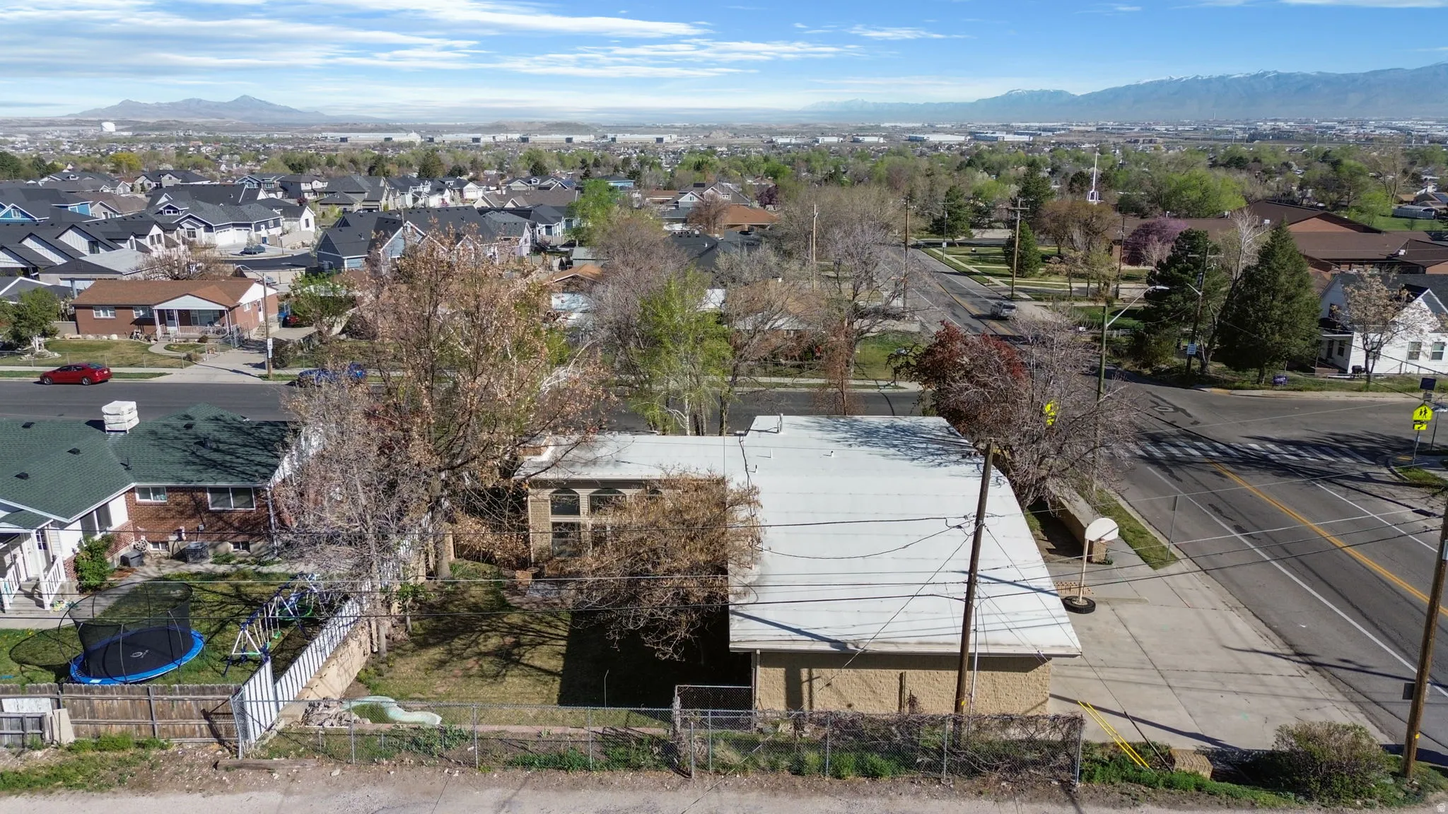 Aerial view of home with garage on the right and fenced in yard on left.