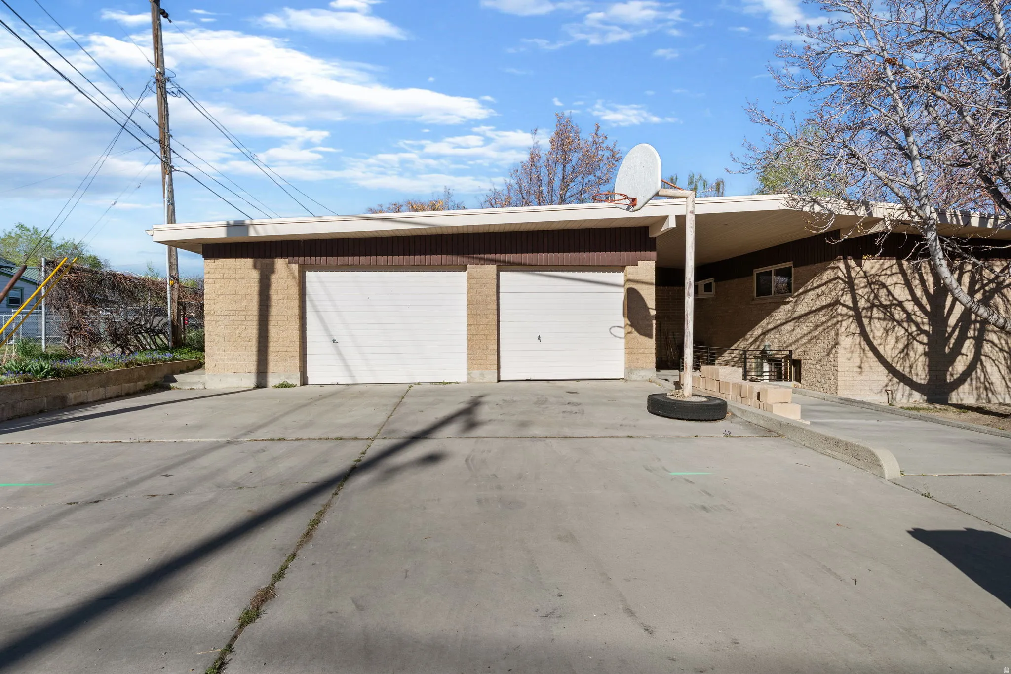 View of side of home showing both garages, oversized driveway, carport for RV/ boat/ toy storage or a covered patio for relaxing and entertaining. (Many Options of how to use this space.)