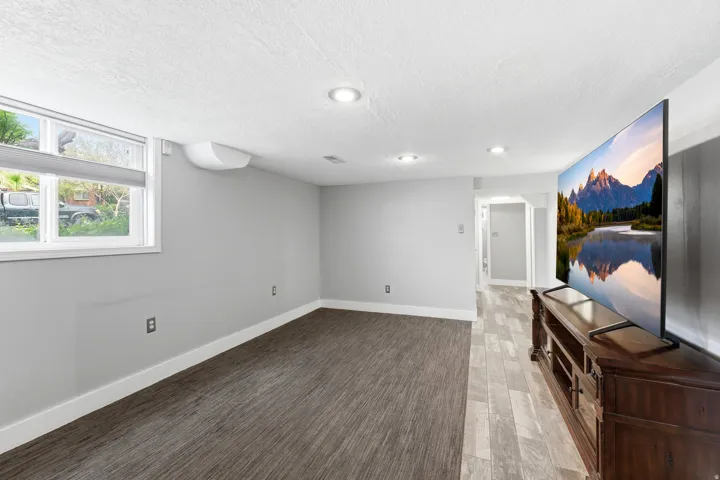 Basement with light wood-type flooring and a textured ceiling