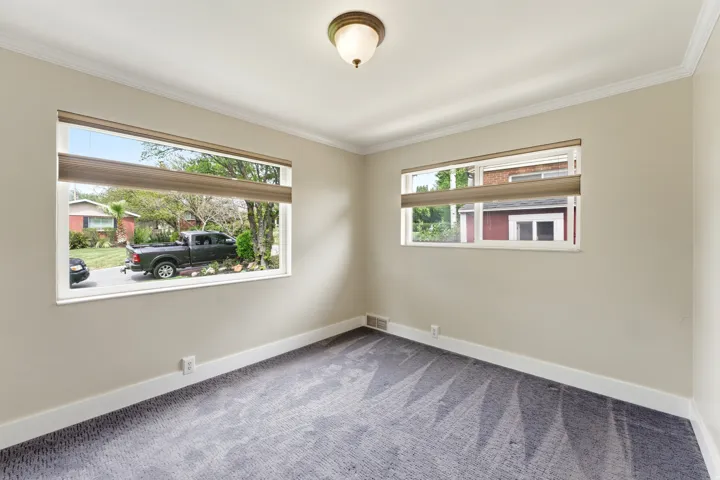 Unfurnished room featuring light colored carpet and ornamental molding