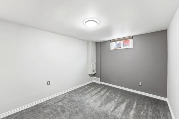 Empty room featuring baseboards and dark colored carpet