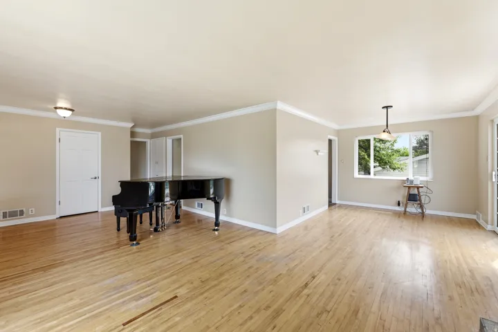 Living room with light wood finished floors and crown molding