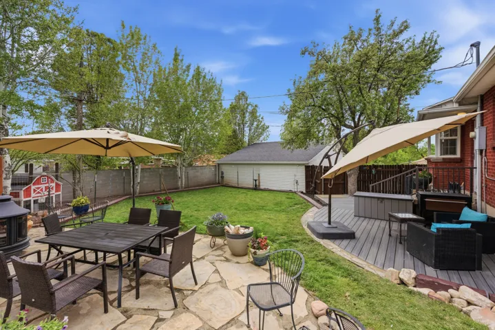 Fenced backyard featuring outdoor dining area, a deck, and a patio area