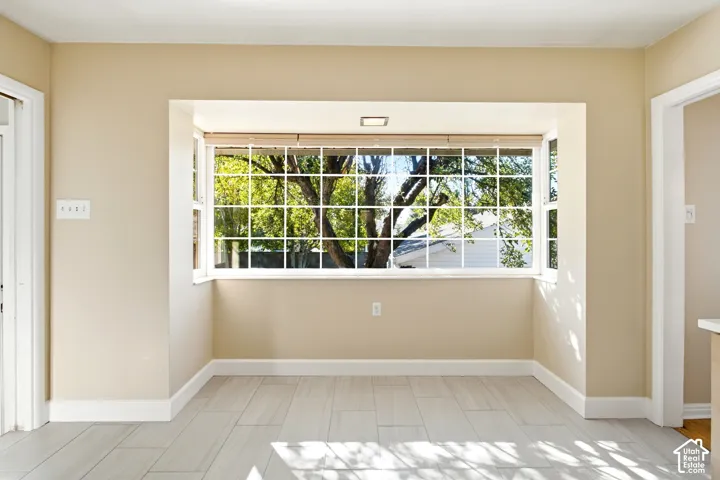 Bay window with white grid panes, light-toned walls, and wood-finish flooring