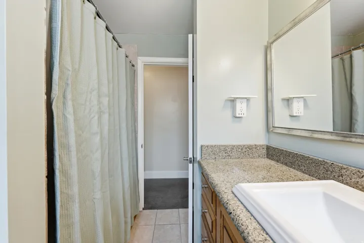 Full bath with vanity, a shower with curtain, and light tile patterned floors