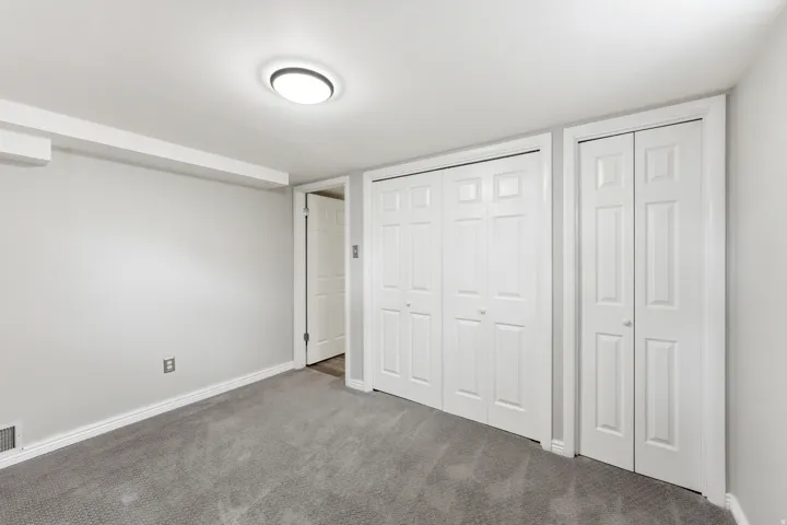 Unfurnished bedroom with two closets and carpet