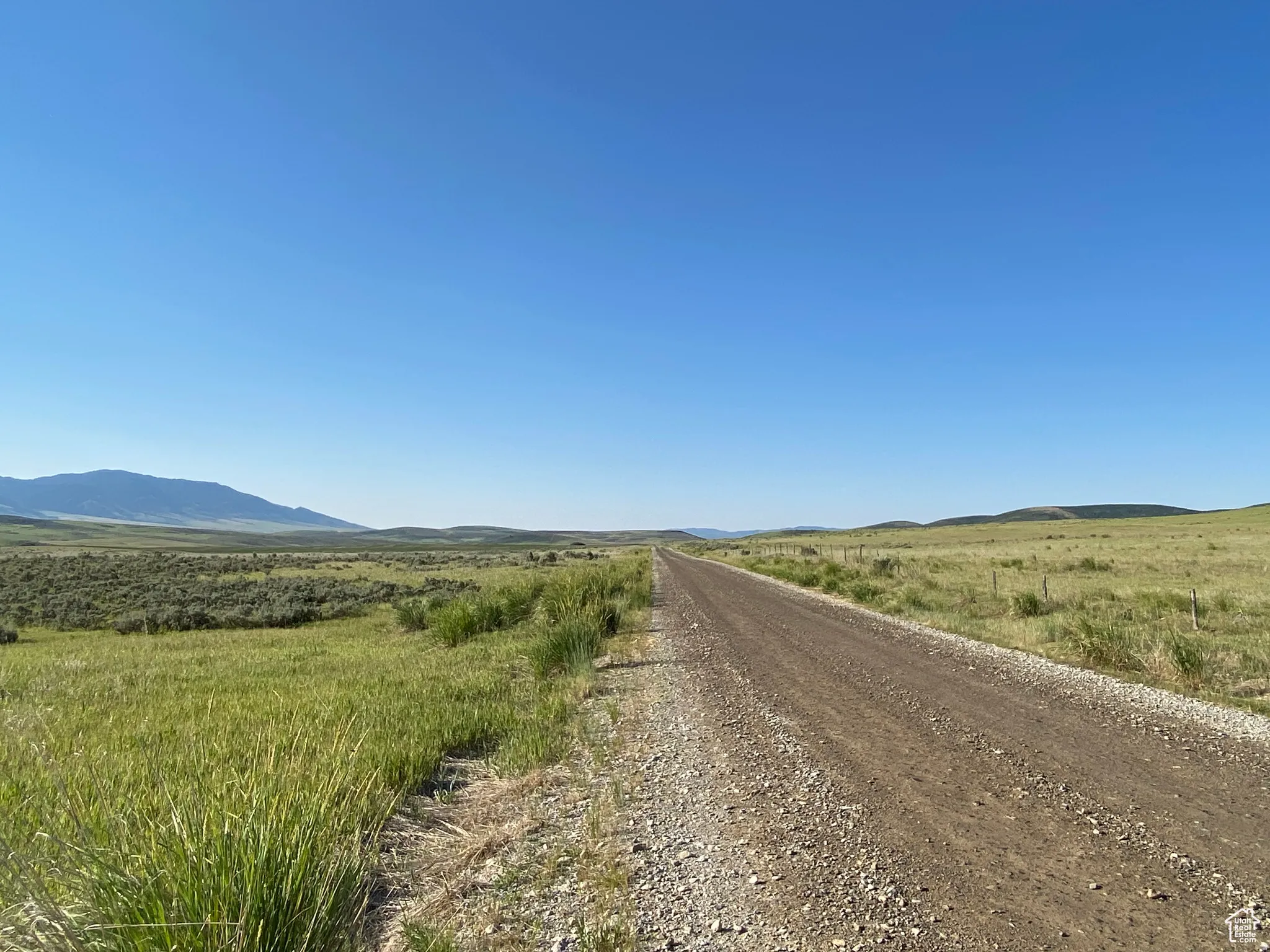 View of dirt / gravel road with a mountain view and a rural view