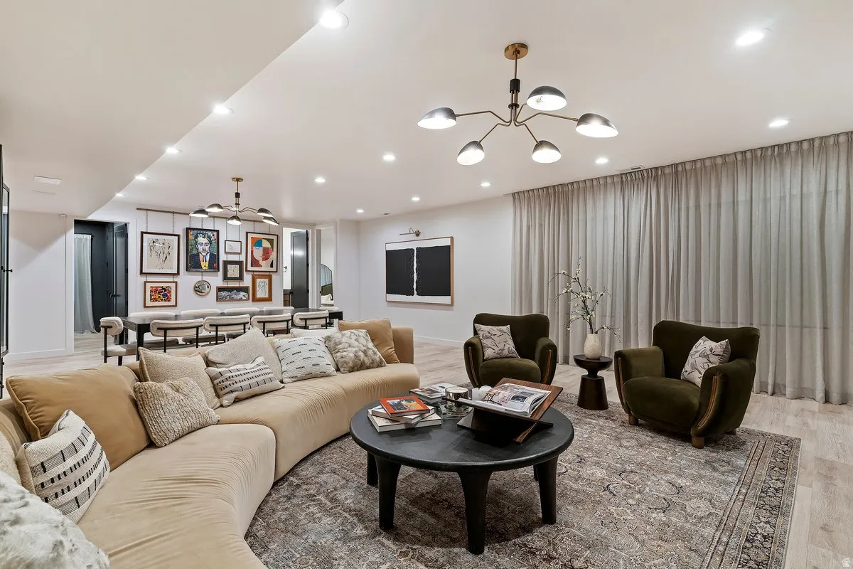 Living area with wood finished floors, ceiling fan, and hanging lights