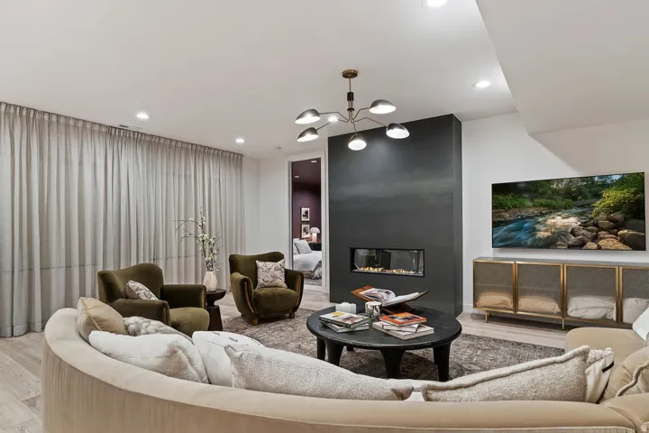Living area with light wood-type flooring, suspended lighting, and a fireplace