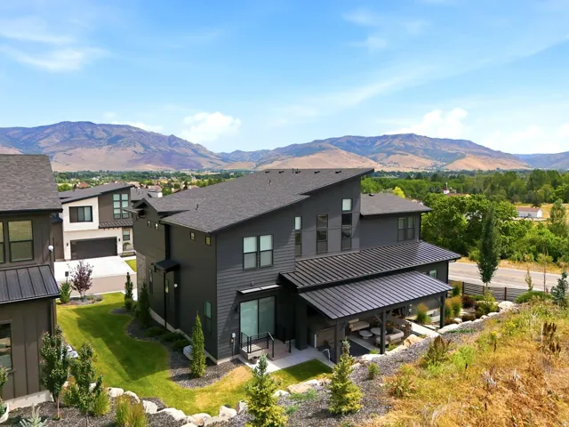 Contemporary charcoal-toned residence featuring multiple gables and a metal-roofed covered patio