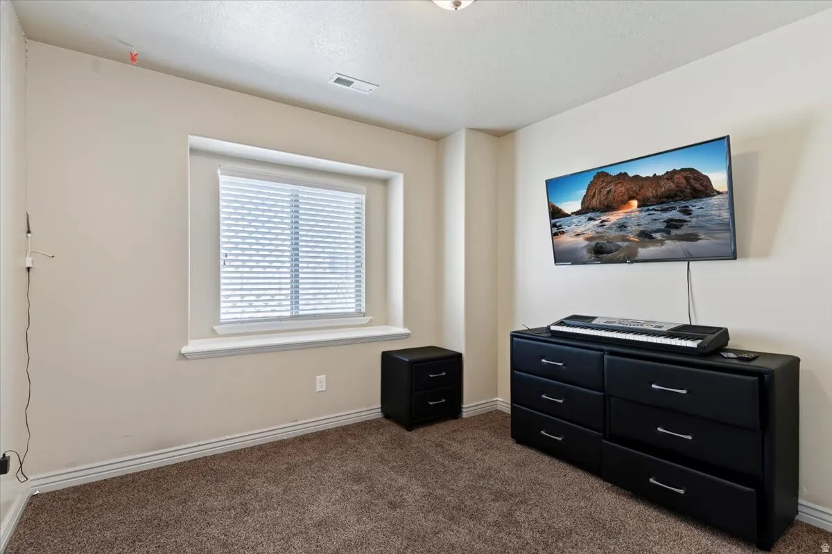 Bedroom featuring dark colored carpet