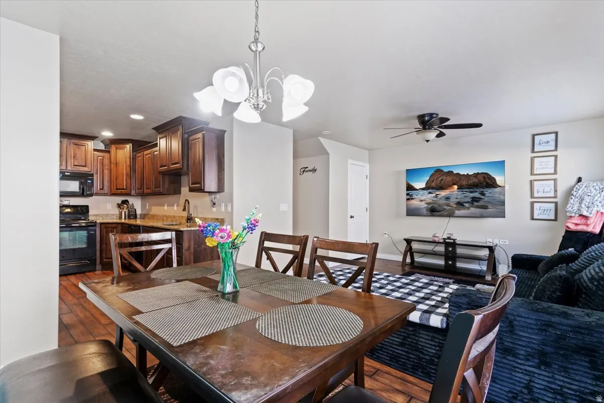 Dining room featuring suspended lighting, dark wood-style flooring, and a ceiling fan