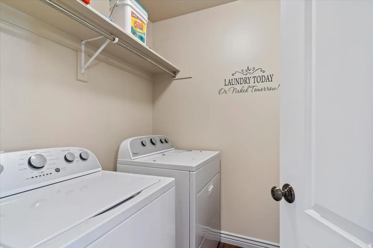 Laundry room featuring washer and clothes dryer and baseboards