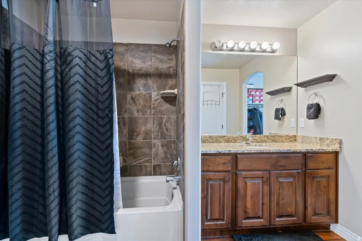 Full bathroom featuring shower / bathtub combination with curtain and vanity