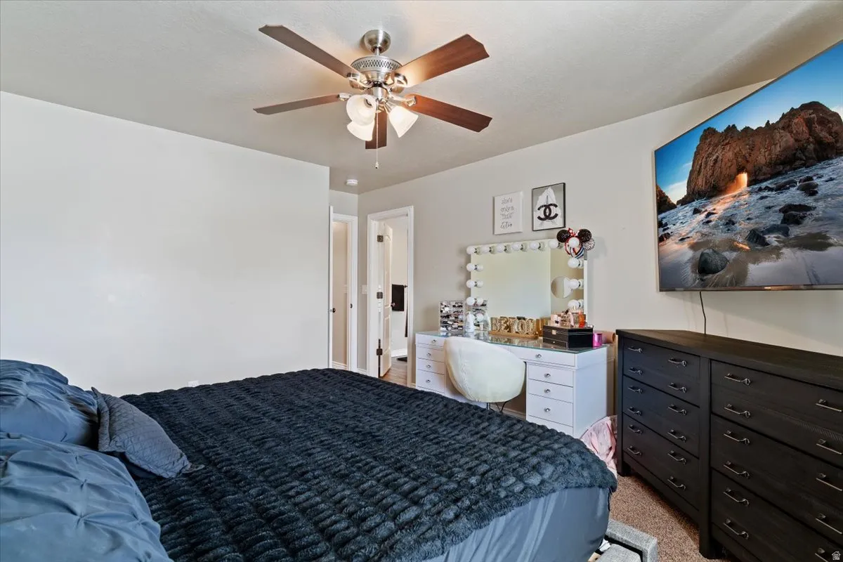 Bedroom with ceiling fan and light carpet