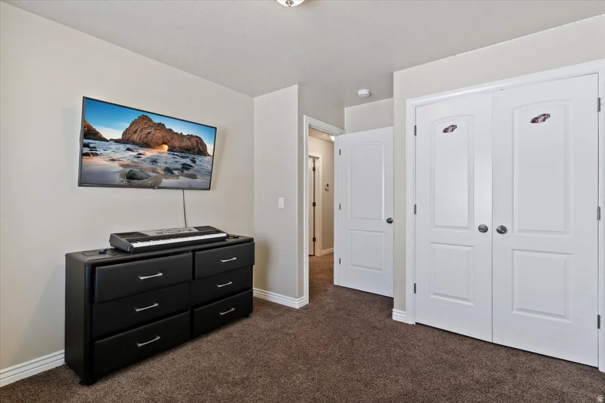 Bedroom featuring dark colored carpet and a closet