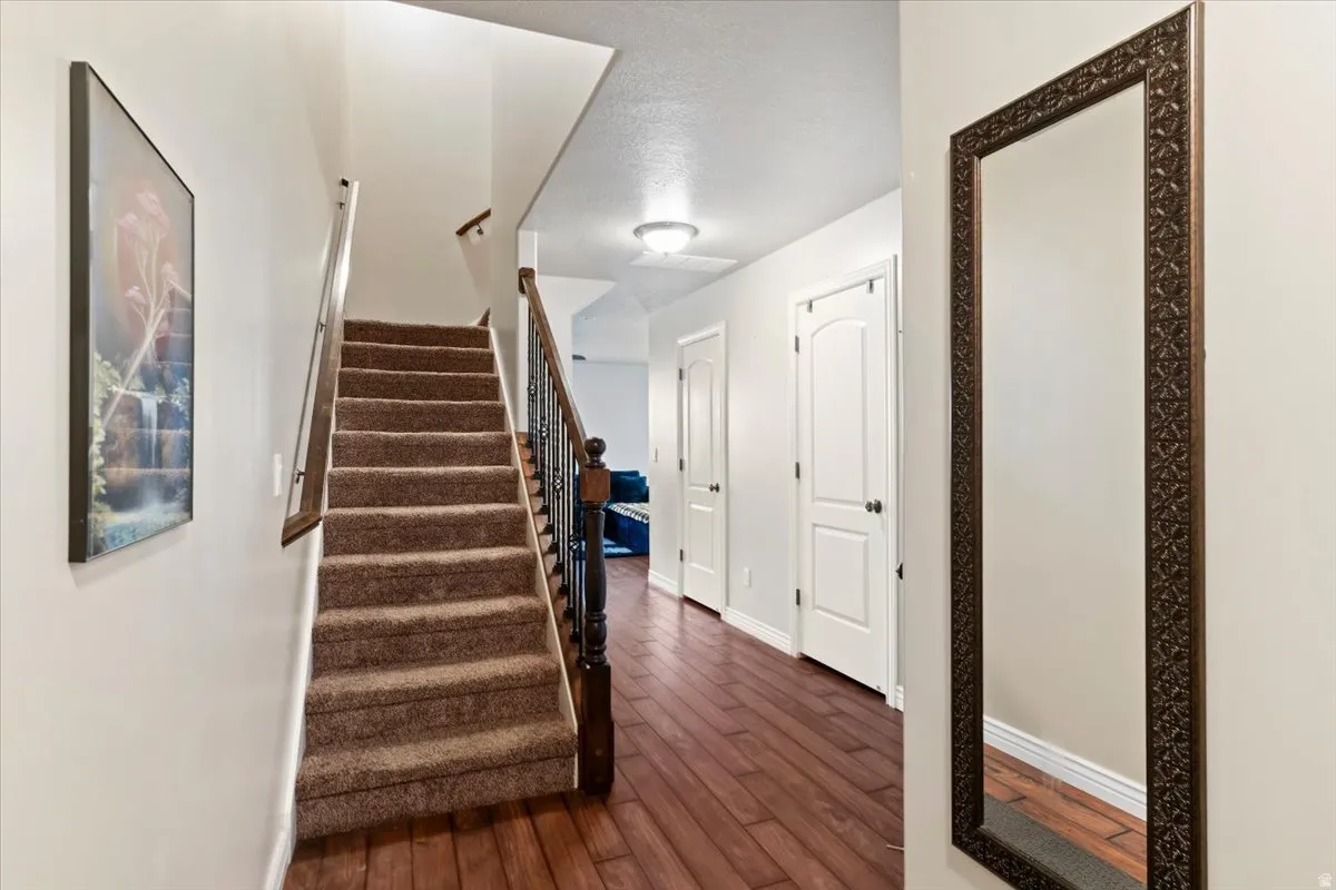 Staircase with hardwood / wood-style flooring and baseboards