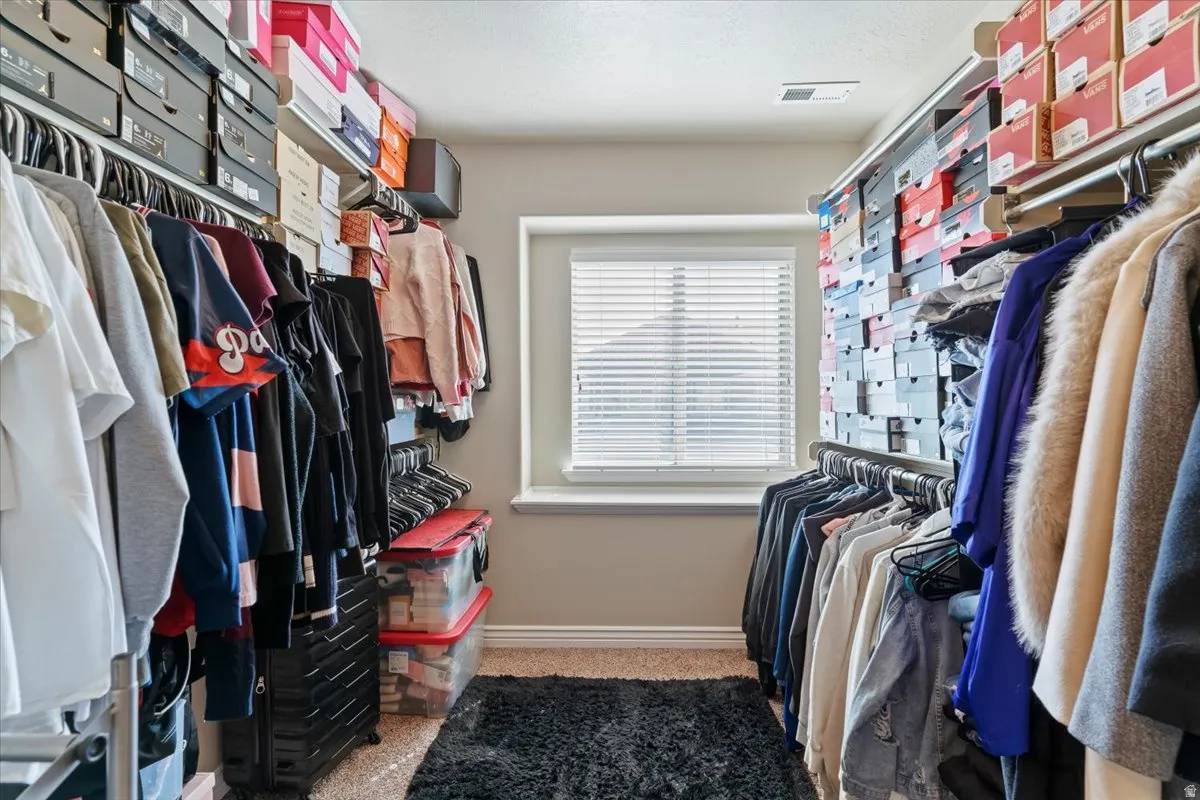 Walk in closet with light carpet